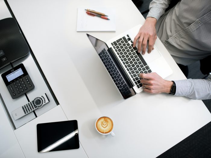 person using laptop on white wooden table